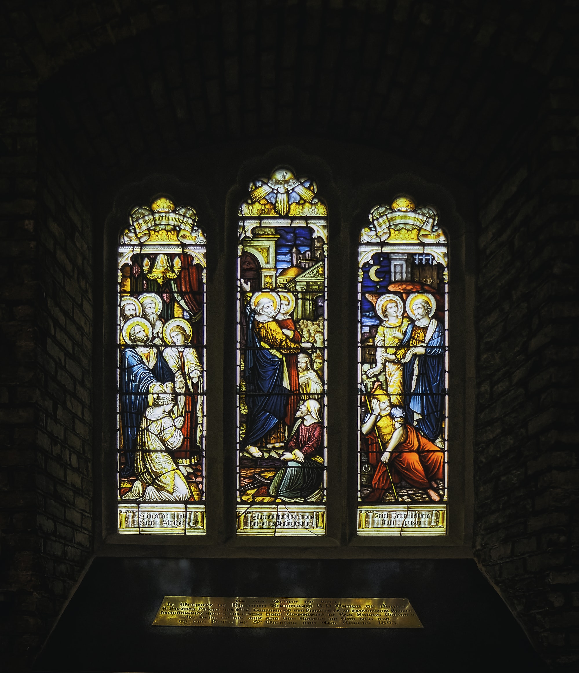 Photo of stained glass windows depicting  a scene from the gospels