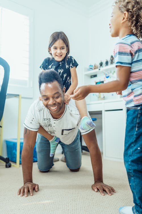 A father and two children playing on the floor