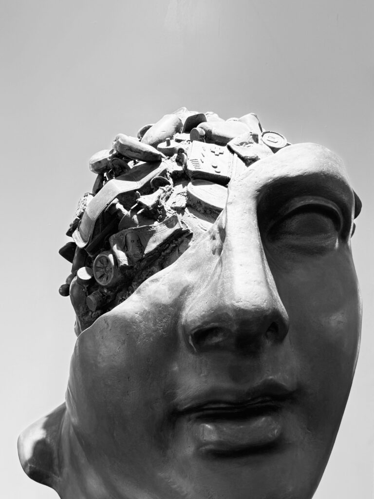 Photo of a sculpture depicting an open head filled with assorted debris